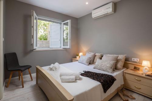 sypialnia z dużym białym łóżkiem i oknem w obiekcie Appartements Banya w Korčuli