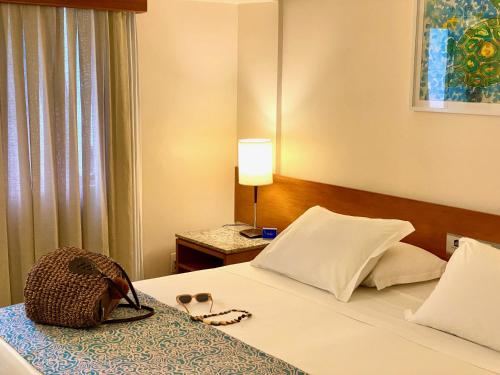 a hotel room with a bed with a purse on it at Kastel Manibu Recife - Boa Viagem in Recife