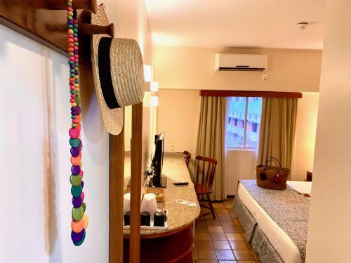 a hotel room with a bed and a desk with a computer at Kastel Manibu Recife - Boa Viagem in Recife