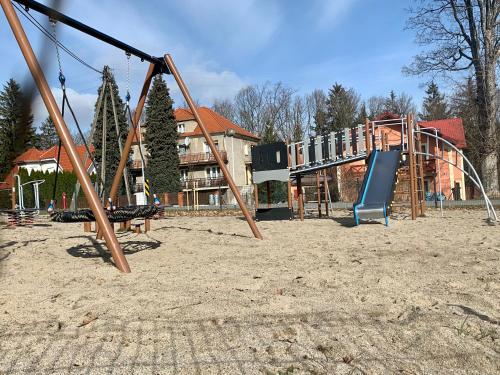 an empty playground with a slide and a swing at 3 Kroki Do Lasu in Polanica-Zdrój