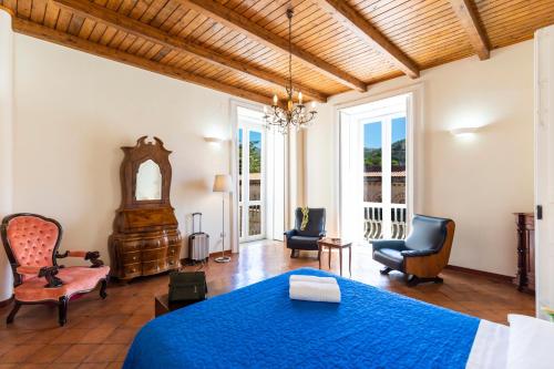 トロペアにあるSuites Pastis Tropea - Boutique B&Bのベッドルーム1室(青いベッド1台、椅子2脚付)