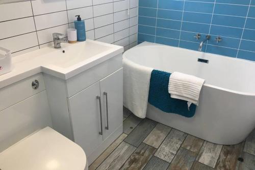 a bathroom with a tub and a toilet and a sink at Stylish holiday let in central Broadstairs in Broadstairs