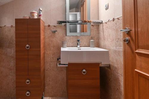 a bathroom with a white sink and a mirror at HEDKO Apartment in Makarska