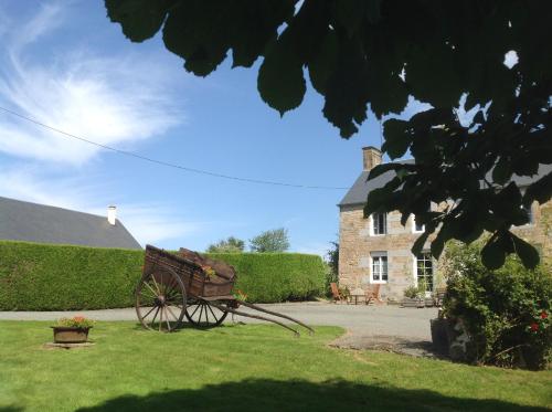 a garden with a bench in front of a building at LES ROCAILLES in La Forêt-Auvray