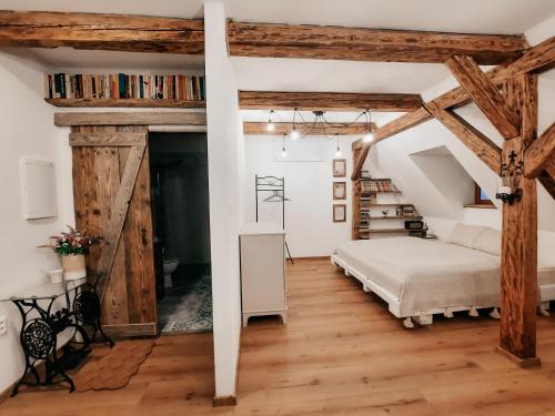 1 dormitorio con cama y vigas de madera en Apartmán v Rezidencii Opera, en Banská Štiavnica