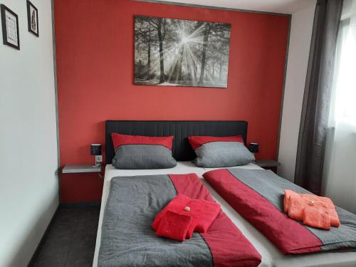 a bedroom with red walls and a bed with red pillows at Zettler`s Ferienwohnung in Aichstetten