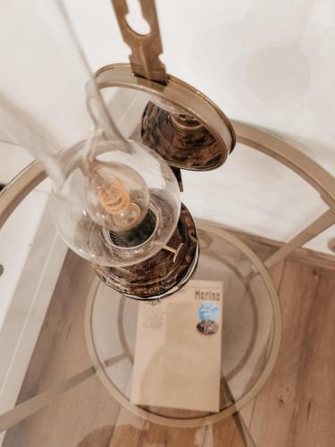 una lámpara de araña con dos vasos encima de una mesa en Apartmán v Rezidencii Opera, en Banská Štiavnica