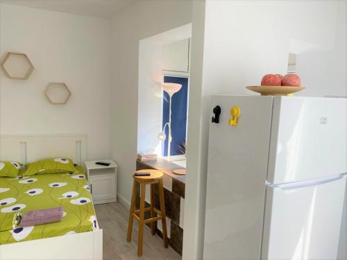 una piccola camera con letto e frigorifero di Central Old Town Studio a Bucarest