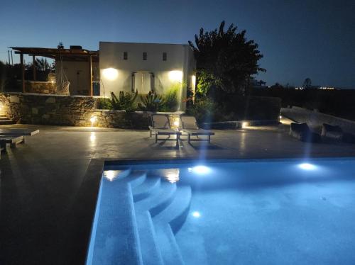 a swimming pool in front of a house at night at Andria's suites in Chrissi Akti