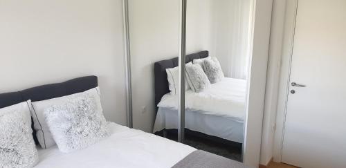 a bedroom with a mirror next to a bed at Apartman Alina Comfort in Banja Luka