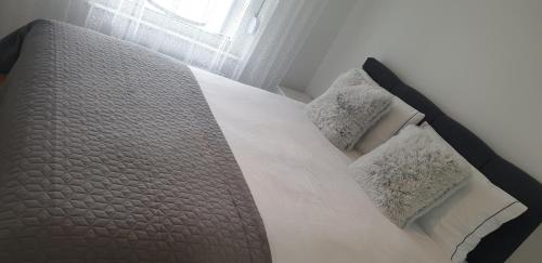 a bed with white sheets and pillows in a bedroom at Apartman Alina Confort in Banja Luka