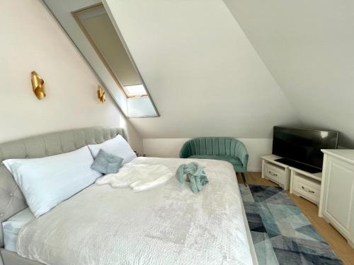 a bedroom with a white bed with a television and a bed sidx sidx at Duna P'Art Panzió in Verőce