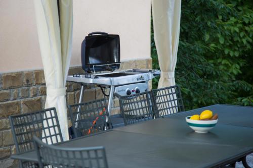 a table with a television and a bowl of fruit on it at Guest house Mikaela in Gabrovo