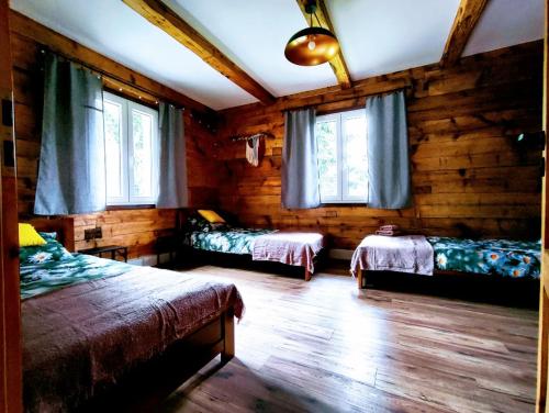a bedroom with two beds in a log cabin at Dusza Chata w Bieszczadach in Myczkowce