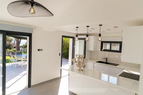 uma cozinha com paredes brancas e um tecto em Villa 6 pers à 30m de la mer em Sainte-Maxime