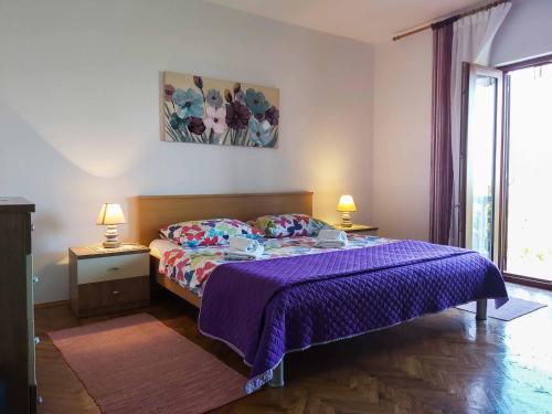 een slaapkamer met een bed met een paarse deken bij Petrcane house in Petrcane