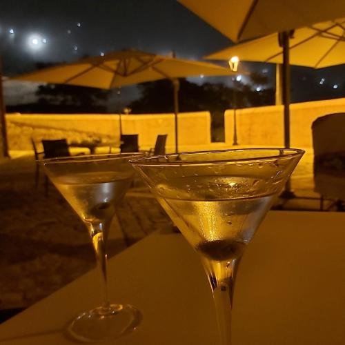 two martini glasses sitting on a table with an umbrella at Al Convento in San Mauro Castelverde