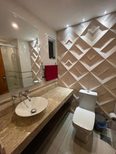 uma casa de banho com um lavatório, um WC e um espelho. em Departamento a 100 metros de la playa em Encarnación