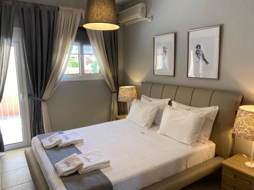 sypialnia z łóżkiem z dwoma ręcznikami w obiekcie Ninemia luxury apartments w mieście Xylokastron