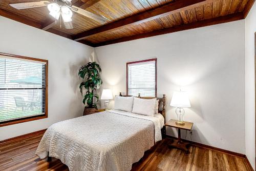 - une chambre avec un lit et un ventilateur de plafond dans l'établissement Little House on LBJ, à Kingsland