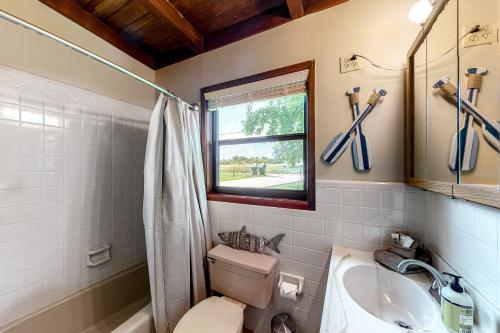 La salle de bains est pourvue de toilettes, d'un lavabo et d'une fenêtre. dans l'établissement Little House on LBJ, à Kingsland