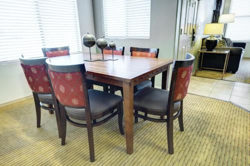 a wooden dining room table with four chairs at Raintree at Phoenix South Mountain Preserve in Phoenix