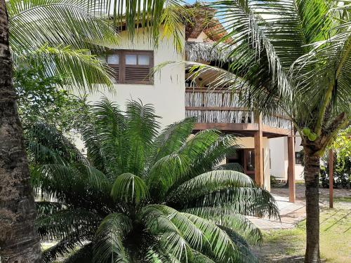a building with palm trees in front of it at Casa na linda praia de Jericoacoara in Jericoacoara