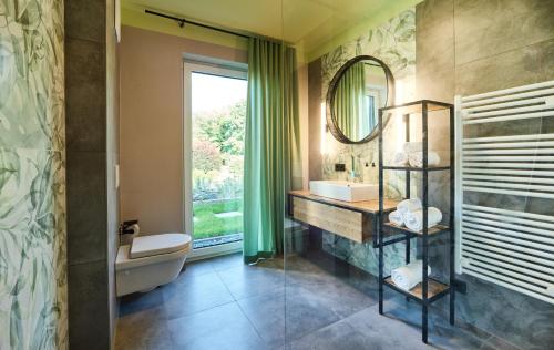 a bathroom with a sink and a mirror at Erasmus Lodge - Ferienwohnungen zum Wohlfühlen in Trassem