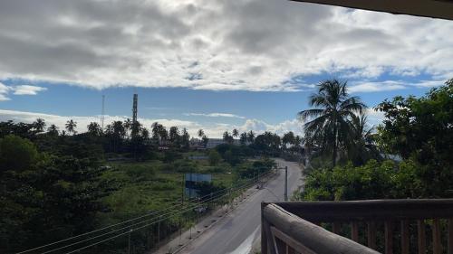 a view from a balcony of a road with a palm tree at Condomínio Barra Bali - apto 234 - Barra de São Miguel - Alagoas in Barra de São Miguel