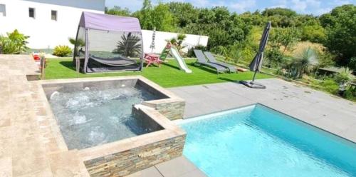 Magnifique villa au calme avec piscine et jacuzzi chauffées في Murviel-lès-Montpellier: مسبح في ساحة بجانب بيت