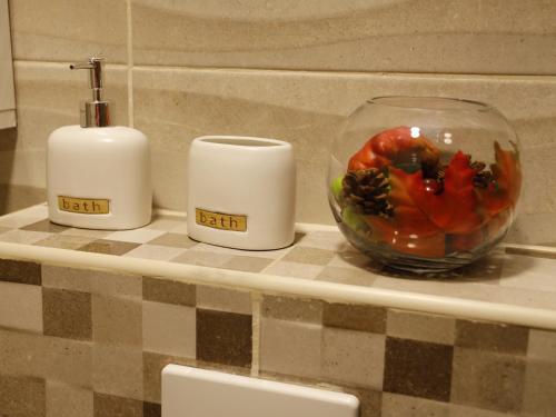 a counter with two candles and a bowl of flowers at Apartment Mona in Podgorica
