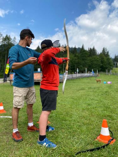 a man and a man holding a stick in a field at Alpin Rose Appartement in Semmering