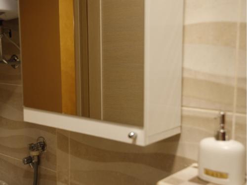 a bathroom sink with a mirror and a soap dispenser at Apartment Mona in Podgorica