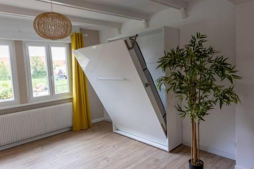 a white staircase in a room with a plant at Maison Privilège Nature à La Petite Pierre in La Petite-Pierre