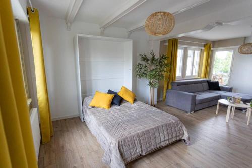 a bedroom with a bed with yellow pillows and a couch at Maison Privilège Nature à La Petite Pierre in La Petite-Pierre