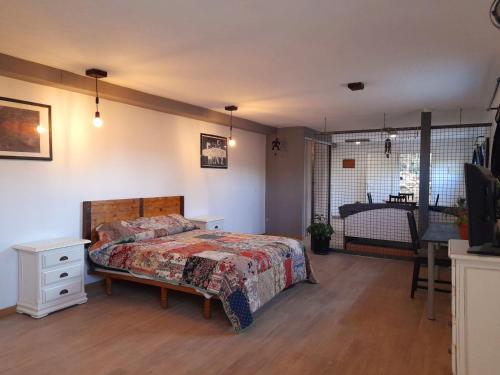 1 dormitorio con cama, mesa y ventana en Oasis Sierra, en Venturada