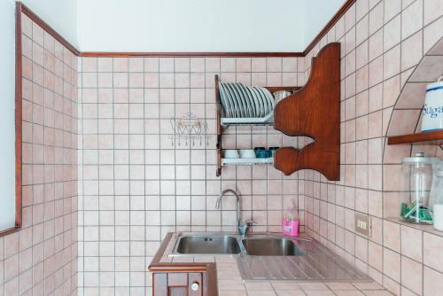 a tiled kitchen with a sink and a shelf at Casa Manu in Atrani