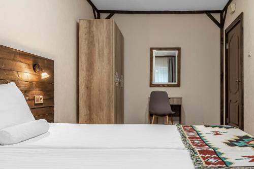 a hotel room with a bed and a chair at Zahar Berkut in Slavske