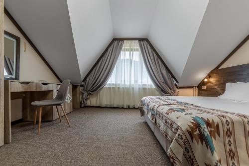 a bedroom with a bed and a desk and a window at Zahar Berkut in Slavske