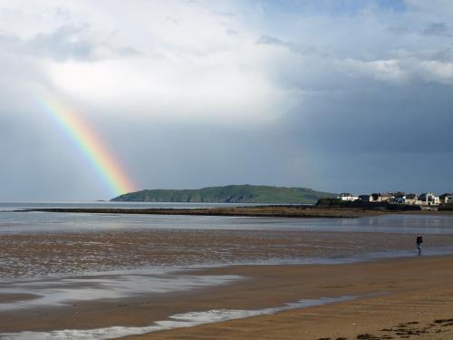 a rainbow over the beach with a person walking on the beach at Argyle Lodge in Rush