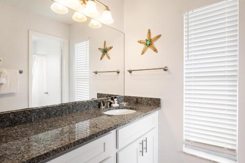 W łazience znajduje się umywalka i lustro. w obiekcie Cozy Home Minutes Away From Disney w mieście Kissimmee