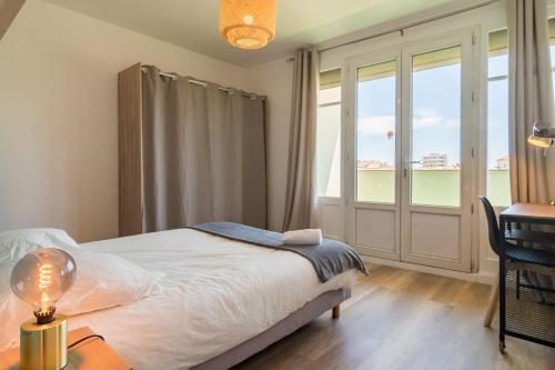 - une chambre avec un lit et un bureau avec une lampe dans l'établissement Appartement cosy et raffiné proche gare Toulon, à Toulon