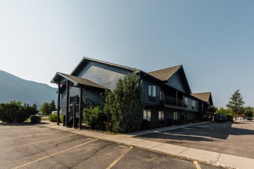 uma casa negra numa rua ao lado de um parque de estacionamento em Wonderstone at Glacier em Columbia Falls