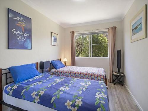 a bedroom with two beds and a window at Dragonfly by Experience Jervis Bay in Vincentia