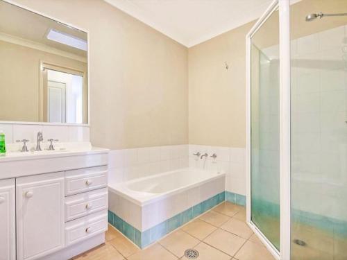 uma casa de banho com uma banheira, um lavatório e um chuveiro em Bella on Jervis by Experience by Jervis Bay em Vincentia
