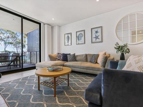 a living room with a couch and a table at 204 on the Beach by Experience Jervis Bay in Huskisson