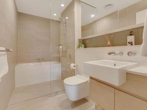 a bathroom with a toilet and a sink and a tub at The Watermark by Experience Jervis Bay in Huskisson