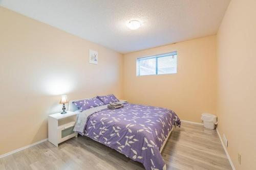 a bedroom with a purple bed and a window at MT Pleasant NW 2 bedrooms 502 in Calgary