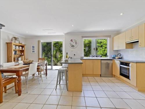 a kitchen and dining room with a table and chairs at Husky House by Experience Jervis Bay in Huskisson