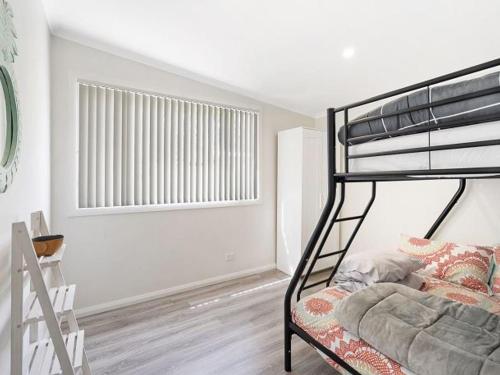a bedroom with a bunk bed and a window at The Shack by Experience Jervis Bay in Vincentia